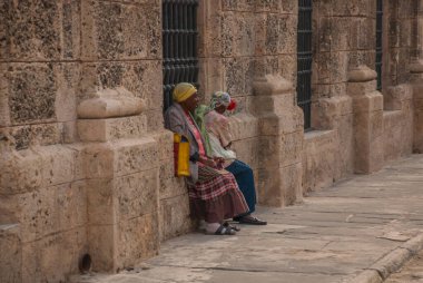 Havana, Küba - Mart 2018: Ulusal kıyafetler giymiş iki kadın oturup turistlerin fotoğraflarını bekliyor