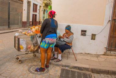 Havana, Küba - Mart 2018: Mahalle sakinleriyle sokak manzarası. Havana şehir merkezinde klasik eski arabaların ve geleneksel renkli binaların olduğu sokak sahnesi.