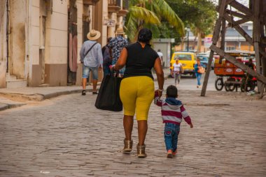 Havana, Küba - Mart 2018: Mahalle sakinleriyle sokak manzarası. Havana şehir merkezinde klasik eski arabaların ve geleneksel renkli binaların olduğu sokak sahnesi.