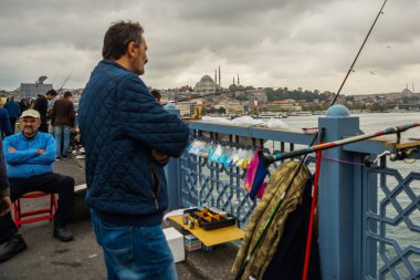 İSTANBUL, TURKEY - Ekim 2018: Bulutlu havada Galata Köprüsü 'nden balık tutan insanlar.