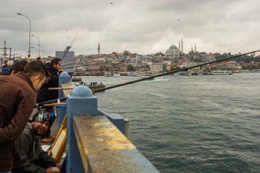 İSTANBUL, TURKEY - Ekim 2018: Bulutlu havada Galata Köprüsü 'nden balık tutan insanlar.