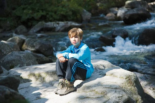 Мальчик сидит у реки — стоковое фото
