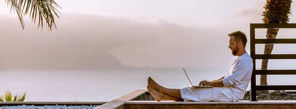 Joven con portátil al atardecer Imágenes de stock libres de derechos