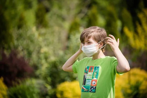 Çocuk yüzüne maske takıyor.