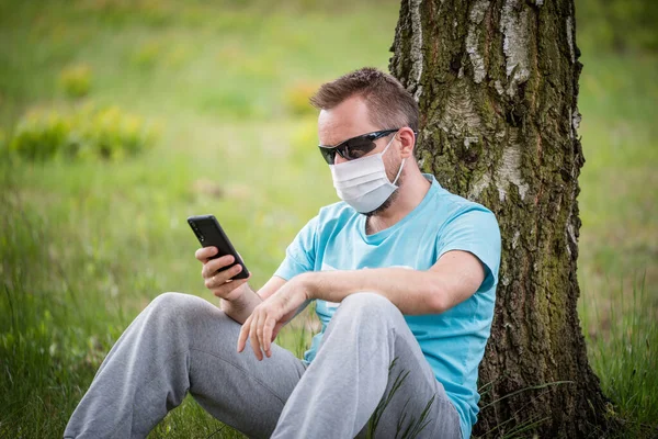 Hombre usando una máscara con teléfono inteligente Fotos de stock libres de derechos