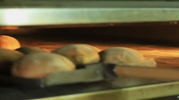 Panadería. El pan horneado se toma del horno — Vídeos de Stock
