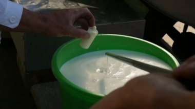 Bir adam süt kalitesini denetler. Yakın çekim.
