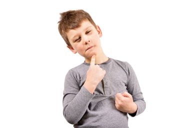 Çocuk gözlerini kısar, parmağını çenesine koyar ve bir şeyler düşünür. Beyaz arkaplandaki çocuk