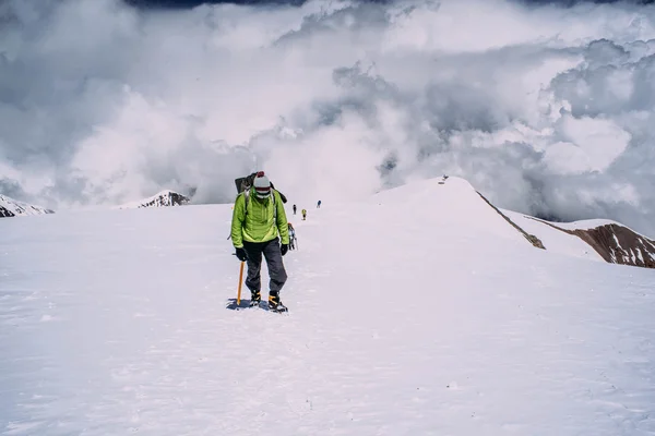 Uomo che si arrampica in alta montagna — Foto Stock