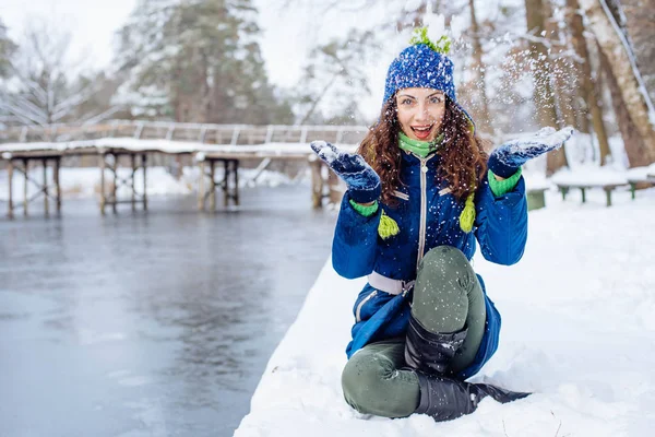 Nuori nainen nauttii talven luminen puisto — kuvapankkivalokuva