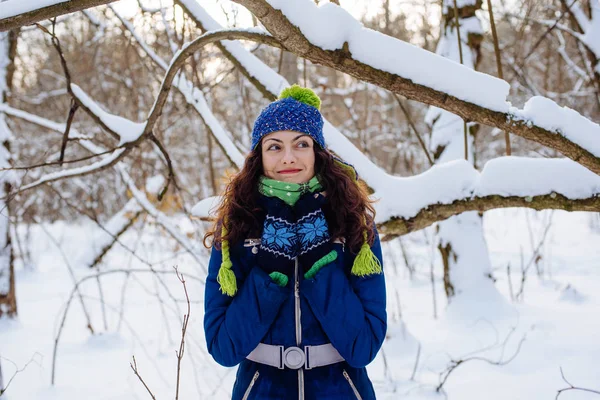 Ung kvinna njuter av vintern i snöig park — Stockfoto