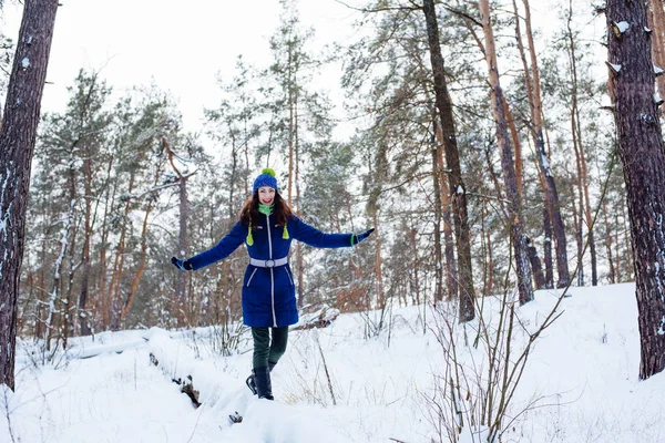 Ung kvinna njuter av vintern i snöig park — Stockfoto