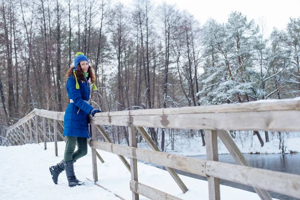 Nuori nainen nauttii talven luminen puisto — kuvapankkivalokuva