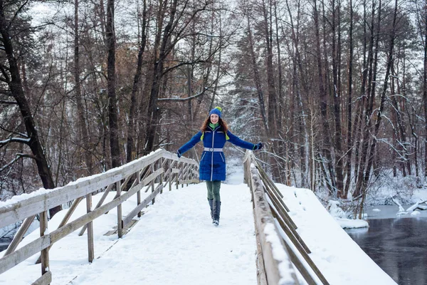 Nuori nainen nauttii talven luminen puisto — kuvapankkivalokuva