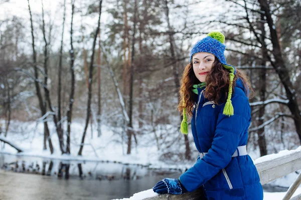 Ung kvinna njuter av vintern i snöig park — Stockfoto