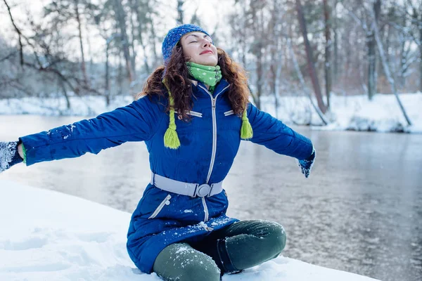 Молодая женщина наслаждается зимой в снежном парке — стоковое фото
