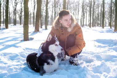 Sibirya husky köpek karlı Park ile oynarken adam