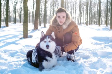 Sibirya husky köpek karlı Park ile oynarken adam