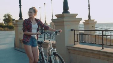 Bisiklet üzerinde gündoğumu günbatımı sırasında sahilde olan güzel kadın
