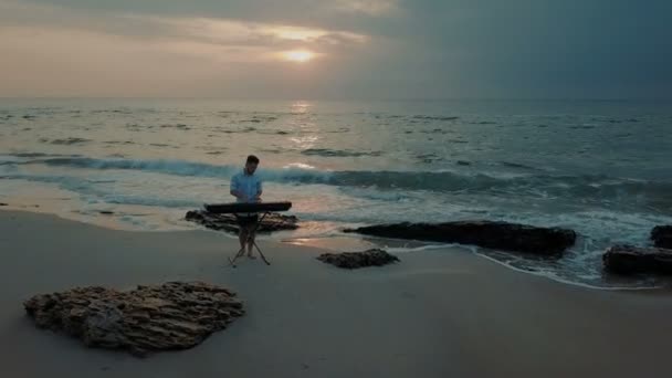 Uomo Che Gioca Sul Sintetizzatore Sulla Spiaggia Durante Tramonto — Video Stock