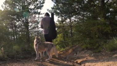 adam gitar ile iki Sibirya husky köpek ormanda yürüyüş ile