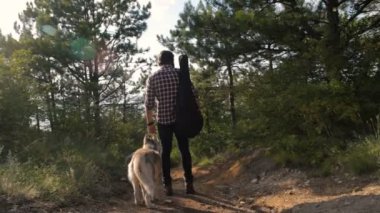 adam gitar ile iki Sibirya husky köpek ormanda yürüyüş ile