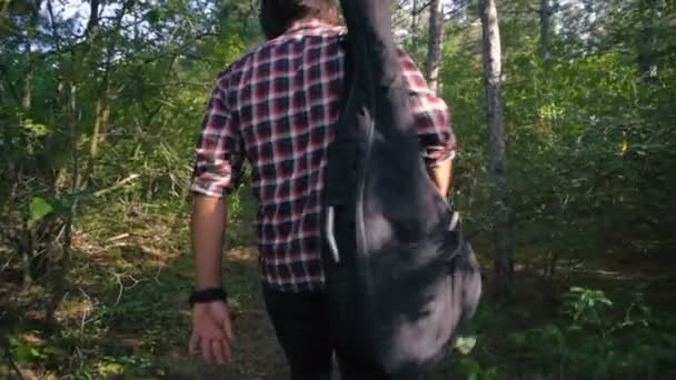 Homem Com Guitarra Andando Floresta — Vídeo de Stock
