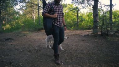 adam gitar ile Sibirya husky köpek ormanda yürüyüş ile