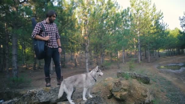 Mannen Med Gitarr Promenader Med Siberian Husky Hunden Skogen — Stockvideo