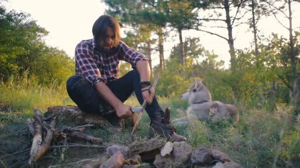 キャンプファイヤーを行う木材のハイカーの男性 — ストック動画