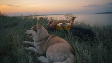 gitar çalmak ile yakın göl günbatımı ışık iki Sibirya husky köpek adam
