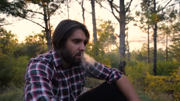 Hipster Hombre Fumar Cigarrillo Sentado Bosque Durante Puesta Del Sol — Vídeos de Stock