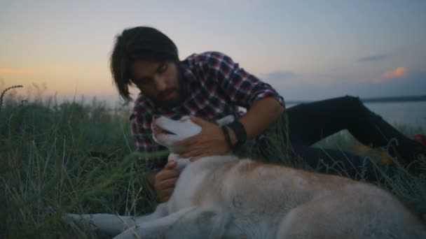 Macho Jugando Con Perro Husky Siberiano Cerca Del Lago Atardecer — Vídeo de stock