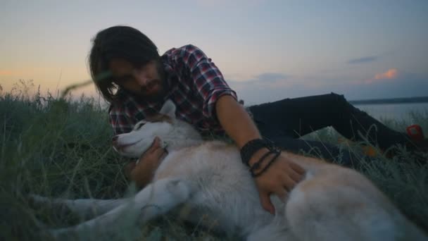 Macho Jugando Con Perro Husky Siberiano Cerca Del Lago Atardecer — Vídeo de stock