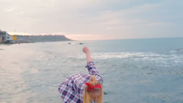 アメリカの国旗と日の出の間にビーチで若い美しい女性 日コンセプト — ストック動画