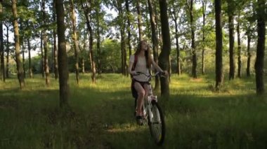 Genç beyaz kadın binicilik bisiklet park