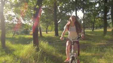 Genç beyaz kadın binicilik bisiklet park