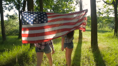iki kız parkta ABD bayrağı ile eğleniyor. 4 Temmuz kutlama arkadaş