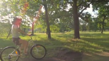 Genç beyaz kadın binicilik bisiklet park