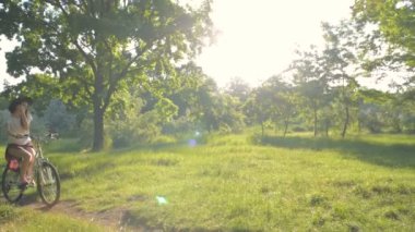 Genç beyaz kadın binicilik bisiklet park