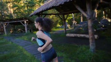 göl yakınındaki ormanda günbatımı veya gündoğumu sırasında çalışan genç sportif erkek