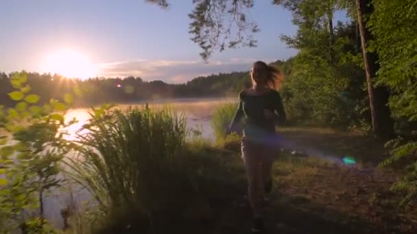 Mladý Sportovní Žena Běží Lese Poblíž Jezera Při Západu Slunce — Stock video