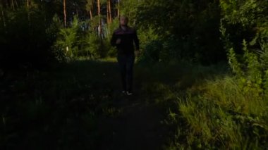 Göl kenarında günbatımı veya gündoğumu sırasında çalışan genç erkek