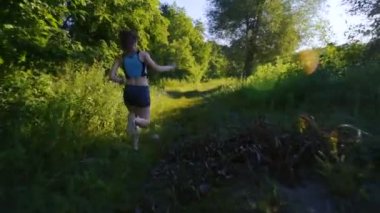 göl yakınındaki ormanda günbatımı veya gündoğumu sırasında çalışan genç erkek
