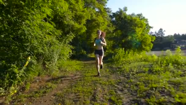 Νεαρή Γυναίκα Τρέχει Στο Δάσος Κοντά Στη Λίμνη Κατά Ηλιοβασίλεμα — Αρχείο Βίντεο