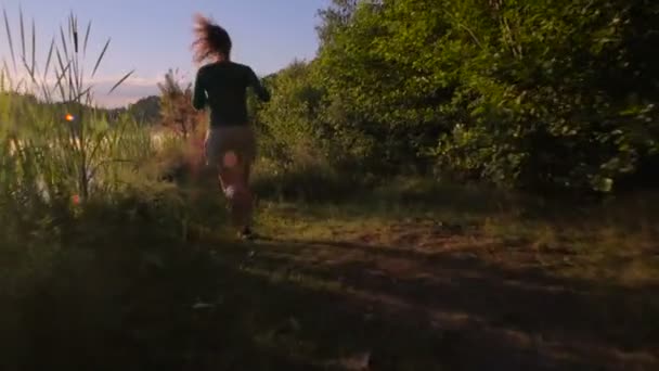 Giovane Donna Che Corre Nella Foresta Vicino Lago Durante Tramonto — Video Stock
