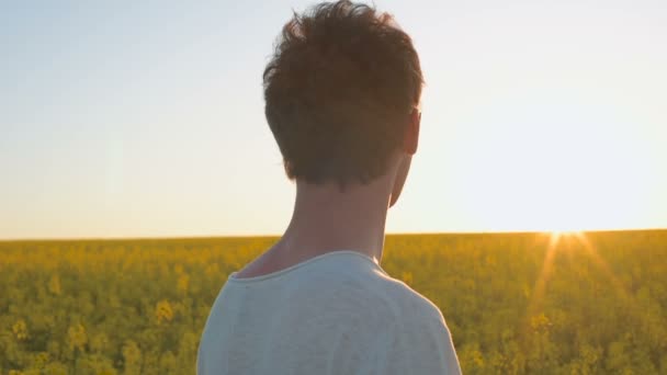 幸せな若い男は 黄色の緑レイプ草原で楽しい時を過す — ストック動画