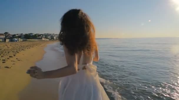 在日落海滩奔跑的年轻美丽的妇女 — 图库视频影像