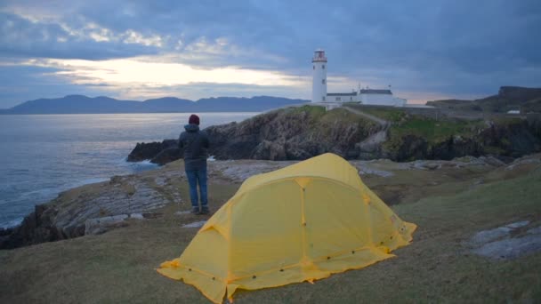 Homem Com Tenda Perto Farol Penhasco Irlanda — Vídeo de Stock