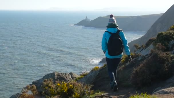 ホウスでアイルランドの海岸の海にハイキング若い白人女性 — ストック動画